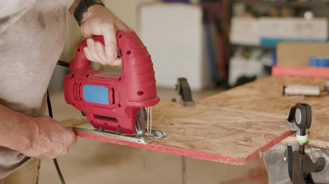 carpenter using a saber saw to cut a plywood circle