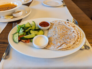 Traditional Crimean Tatar Dish Yantyk Served with Fresh Salad and Dips.Restaurant Lunch with Yantyk and Lentil Soup.Authentic Eastern European Cuisine: Plate of Yantyk with Vegetable Salad