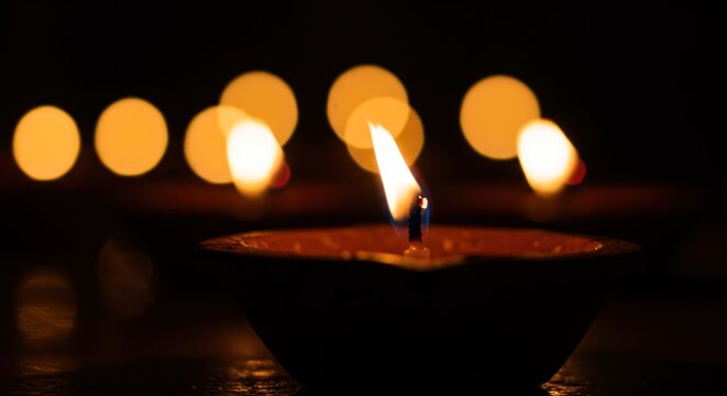 Illuminating Diwali A Single Clay Lamp's Warm Glow Amidst Festive Lights