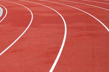 Red artificial running track with white round dividing lines, treadmill rubber texture, sports,...