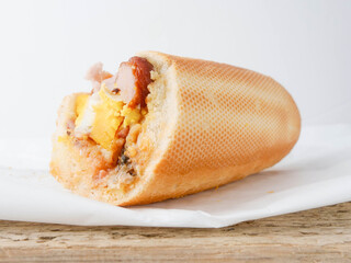 Traditional tasty Irish breakfast roll with white bread, sausage, bacon or rasher, fried egg and...