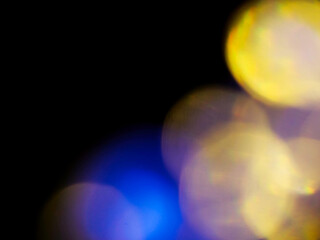 Abstract bokeh scene. Golden and blue glowing light leaks on black color background for design....