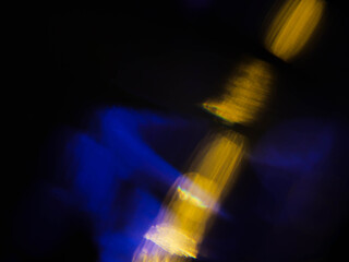 Abstract bokeh scene. Golden and blue glowing light leaks on black color background for design....