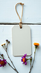 Blank Kraft Tag with Dried Flowers on White Wooden Background vertical
