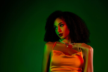 Elegant young lady wearing a stylish cocktail dress expressing glamour and charm on a gradient...