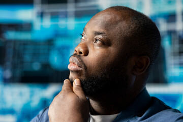 Black businessman using smart technology to interact with cybernetic platforms and AI interfaces, representing the integration of machine learning and predictive analytics in modern development.