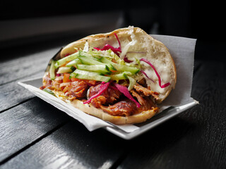 A sandwich with cucumber and red onions on a white plate