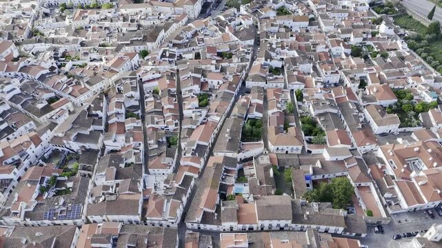 Drone flies bird's eye view over the city of Evora, Portugal with white houses with orange roofs