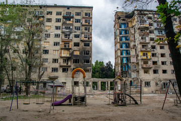 Children's playground standing in the courtyard amidst destroyed residential buildings in Kyiv,...