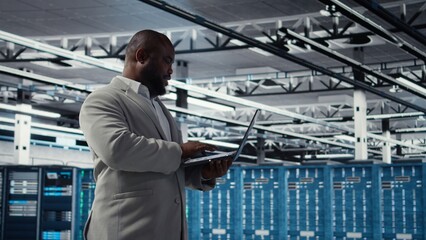 Smiling data center technician installing and upgrading hardware components. Happy server farm...