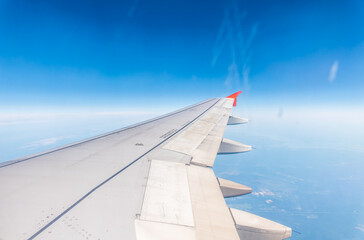 View from the airplane window at a beautiful cloudy sky and the airplane wing