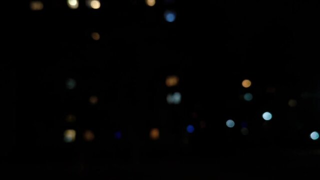 side view of city at night from car window. Blurred lights in background. city's night lights. Driving through city at night. night traffic in the city