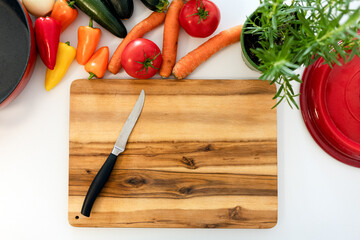 top view cutting board with knife and fresh vegetables: carrots, eggplant, tomatoes, onions, zucchini. cooking vegetable stew. benefits of fresh vegetable dishes, vegetarianism