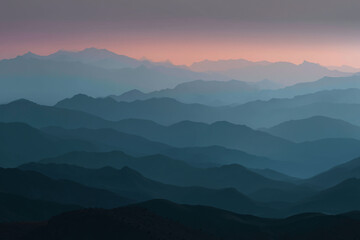 Obraz premium Mountain range at sunset in blue