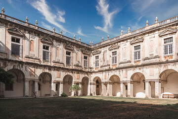 Obraz premium Elegant courtyard of an old Lisbon monastery featuring arched walkways, weathered stone, and classical architecture, ideal for history, travel, and cultural heritage visuals.