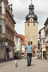 Obraz premium Active senior man walking with Jack Russell terrier in historic Coburg street