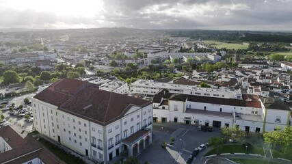 Drone flies toward Garcia de Rezende Theater at sunset in Evora, Portugal