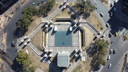 Zenithal drone photo of the Museo Metropolitano de Arte Urbano in Córdoba, Argentina, showcasing colorful urban artwork and murals on rooftops and streets, surrounded by city buildings.