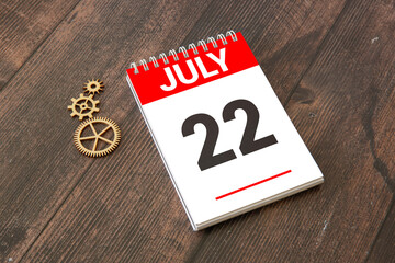 calendar with an important event for July 22 on a table with hibiscus flowers.
