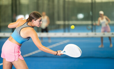 Portrait of cheerful girl paddle tennis player during friendly doubles couple match at court