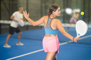 Padel game - girl with partners plays on the tennis court