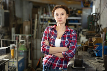 Portrait of confident female worker in workshop of a metallurgical plant