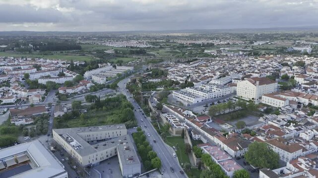 Drone lowers outside walled city on cloudy afternoon in Evora, Portugal