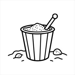 A sand bucket with a shovel situated on a surface covered in sand
