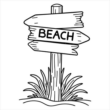 A signpost pointing towards the beach stands in sand surrounded by grass