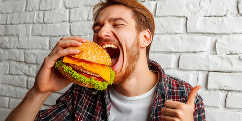 Happy man taking a bite of a tasty cheeseburger with a thumbs-up.
