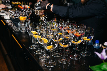Bartender preparing cocktails at event bar.
