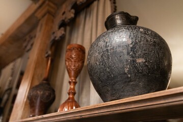 Rustic Clay Pottery and Wooden Goblets on Shelf.