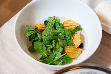 Fresh mint leaves with physalis and blueberries.