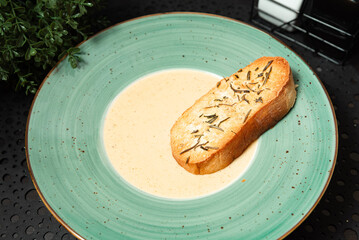 Creamy Soup with Herb Crouton in Green Plate.