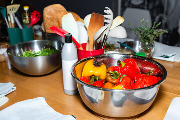 Colorful bell peppers in stainless kitchen bowl.
