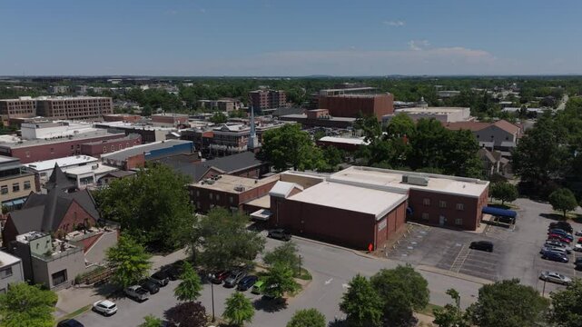 lower view of downtown Bentonville Arkansas flying back alongside iconic water tank
