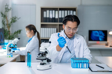 Scientist using micropipette filling test tubes in laboratory