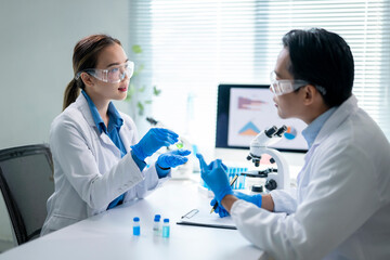 Scientists discussing about liquid sample during medical research in laboratory