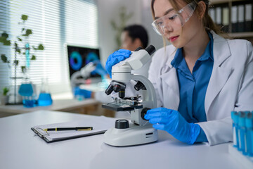 Scientist using microscope doing research in laboratory