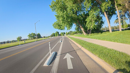 Bike lane separated from a car traffic on a street in Fort Collins, Colorado - biking POV