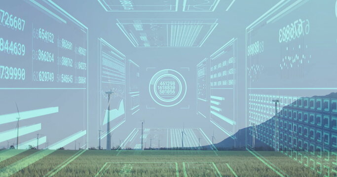 Displaying white wind turbines spinning across grassy plain at wind farm, with digital data charts