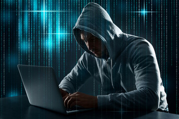 Cyber attack. Hacker working with laptop at table. Binary code around him