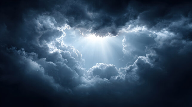 Fototapeta Dramatic dark stormy sky with thick clouds opening to reveal bright sunlight rays breaking through, creating powerful and moody atmosphere