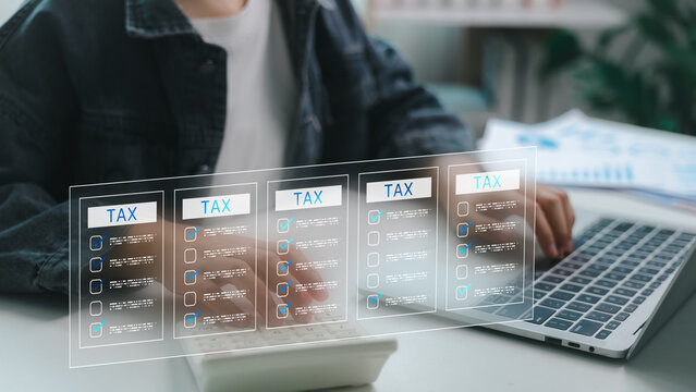 Close-up of person using calculator and laptop with digital tax forms on screen. Concept of online tax filing, financial technology, e-filing system, accounting software, and tax automation.