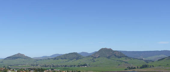 Obraz premium Morro Bay's Green Hills under a Clear Sky