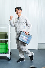 工具箱を持つ作業着を着た男性