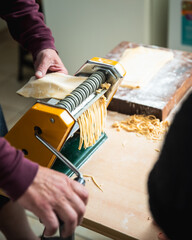 Man making homemade pasta with a noodle machine