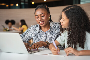 Female Tutor Guiding Student with Homework and Computer, Teacher and Student Collaborating on...