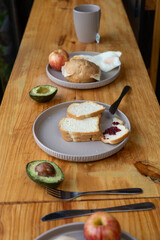 The breakfast table is set with colorful fresh fruits, warm pastries, steaming coffee, and other nutritious dishes, creating an inviting and energizing morning meal scene.

