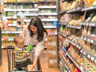 woman is shopping with her baby in a grocery store